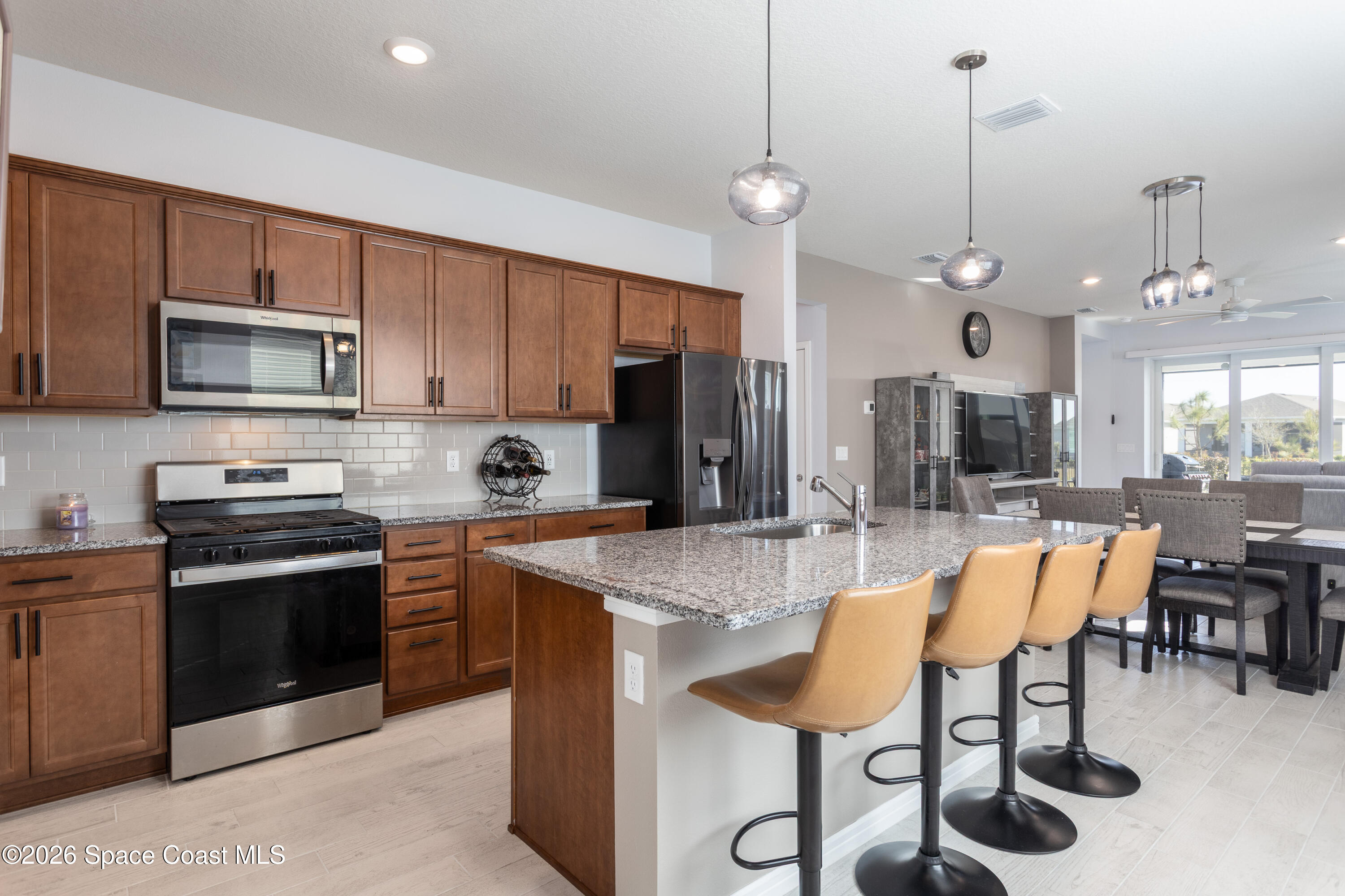 2993 Tidepool Place Melbourne, FL 32940 - Photo 7 of 50 a kitchen with stainless steel appliances granite countertop a stove a sink a dining table and chairs
