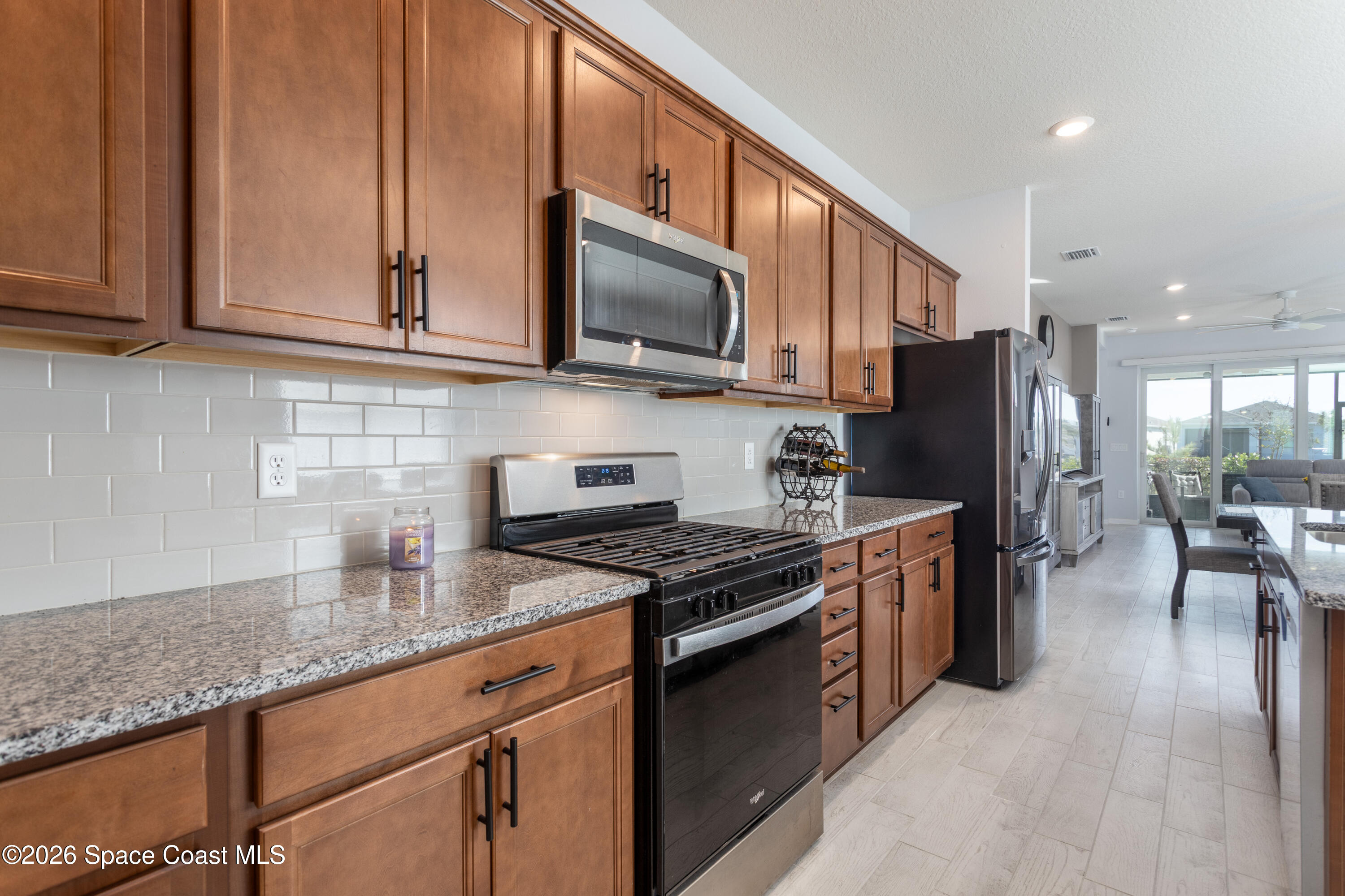 2993 Tidepool Place Melbourne, FL 32940 - Photo 9 of 50 a kitchen with stainless steel appliances granite countertop a stove a sink dishwasher a refrigerator and a microwave
