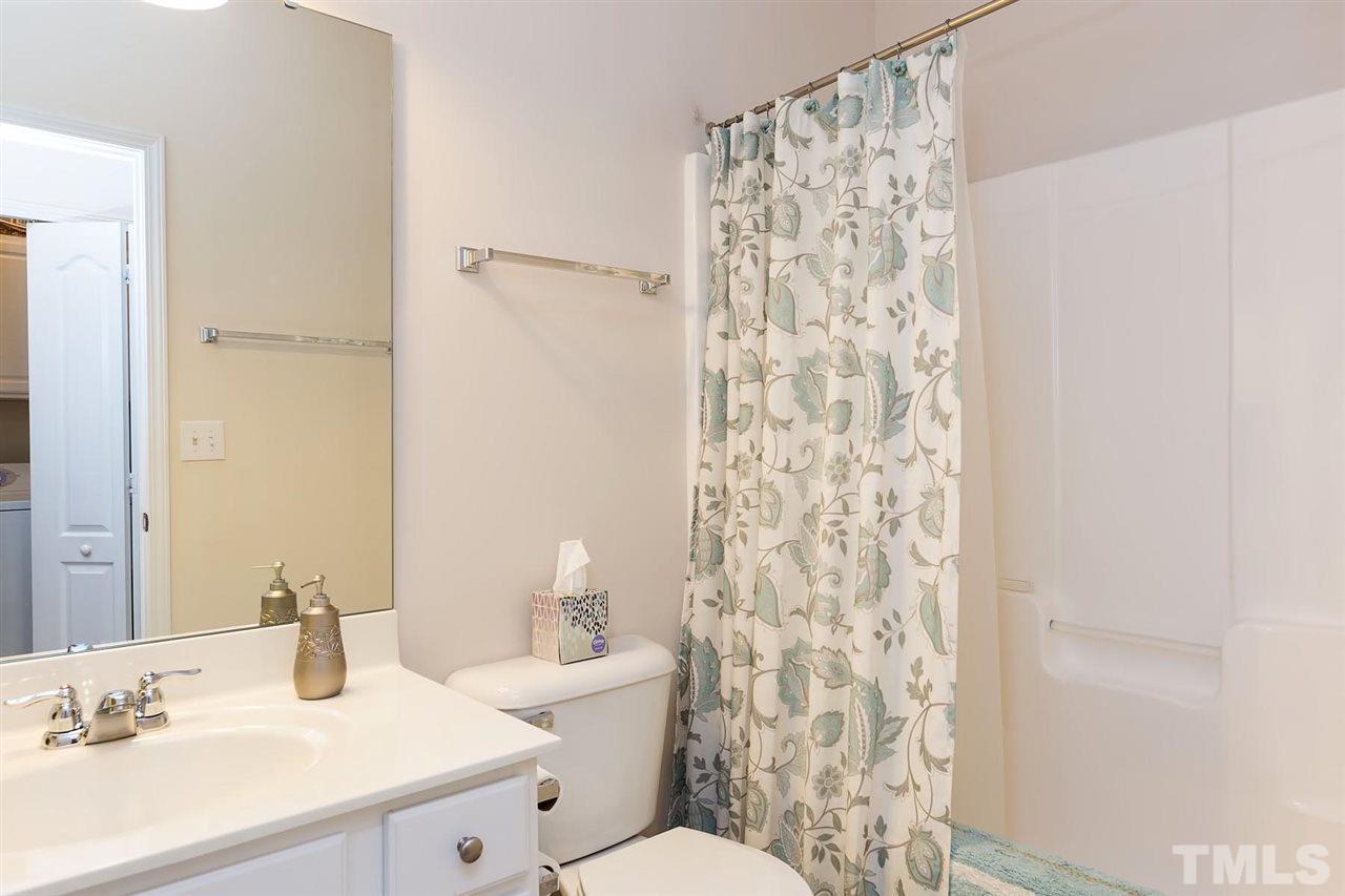 3413 Secretariat Way Raleigh, NC 27614 - Photo 13 of 23 a bathroom with a sink a toilet and shower curtain