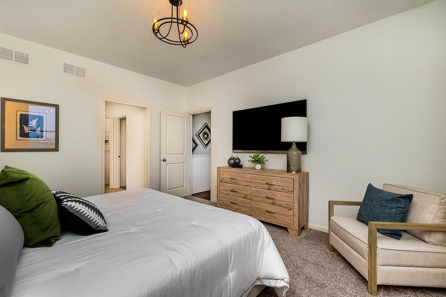 7754 West 103rd Street St. John, IN 46307 - Photo 19 of 39 a bedroom with a bed and a flat screen tv