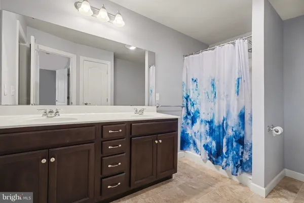 a bathroom with a double vanity sink and a mirror