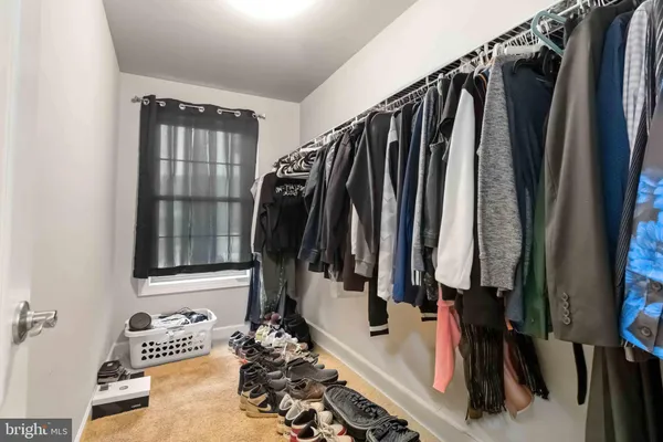 a view of walk in closet with clothes and shoes