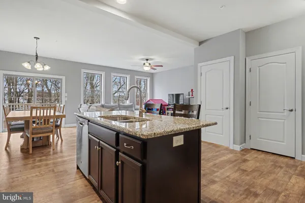 a kitchen with granite countertop a stove dining table chairs and a large window