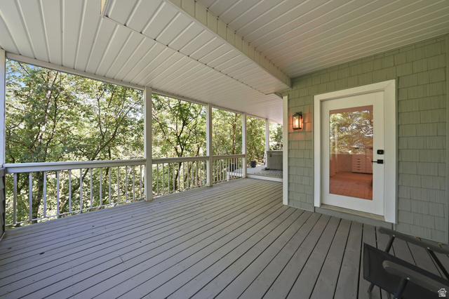 1979 Cave Hollow Way Bountiful, UT 84010 - Photo 44 of 59 Expansive covered deck featuring wood-finish flooring, white spindle railings, and a full-light glass door