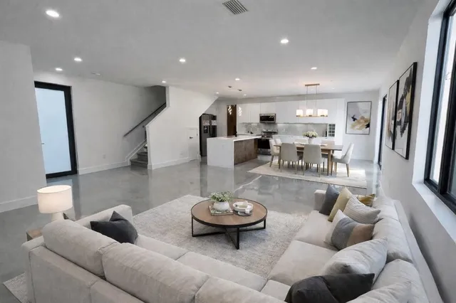 a living room with furniture and a view of kitchen