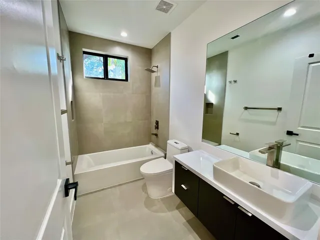 a bathroom with a double vanity sink toilet mirror and bathtub