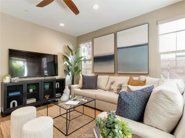 a living room with furniture a flat screen tv and a large window