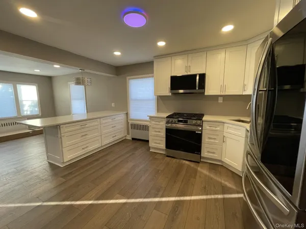 a kitchen with stainless steel appliances kitchen island granite countertop a refrigerator and a stove top oven