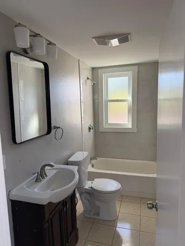 a bathroom with a granite countertop sink toilet and mirror