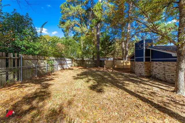 a view of a yard with plants and trees