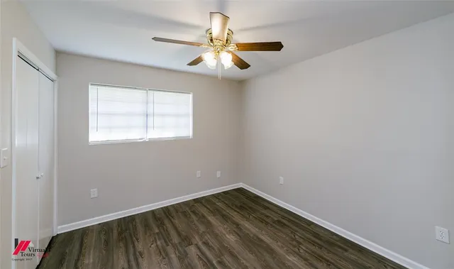 an empty room with a window and a fan
