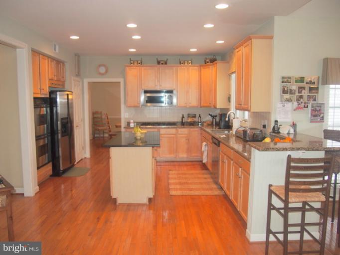 14407 Bubbling Spring Road Boyds, MD 20841 - Photo 29 of 30 a large kitchen with stainless steel appliances kitchen island granite countertop a large counter top stainless steel appliances and cabinets