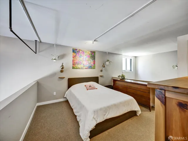 a bedroom with a bed and a large mirror on the dresser