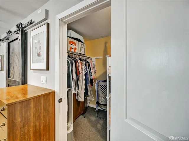 a view of walk in closet with clothes