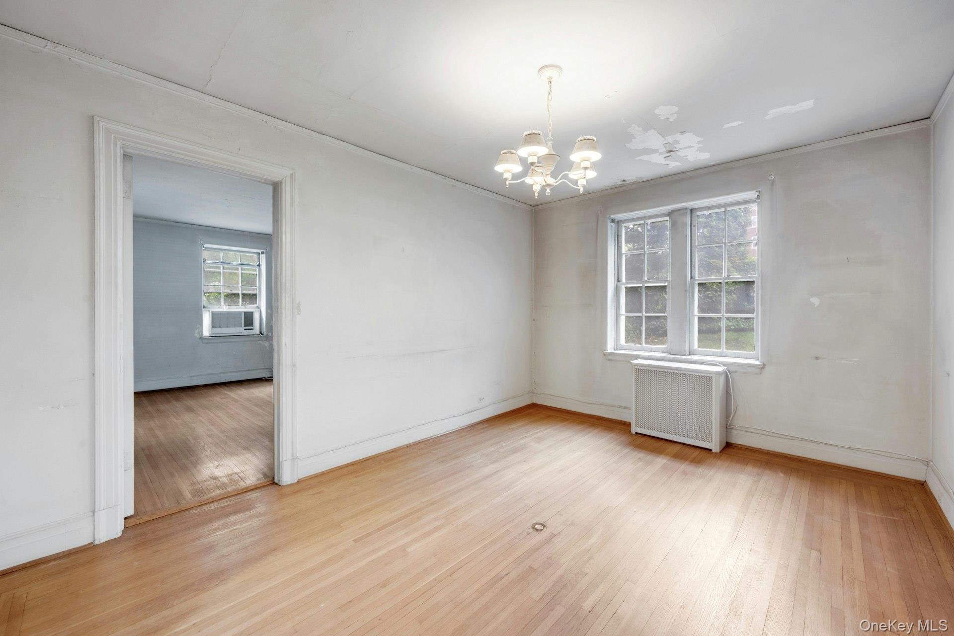 3 Alden Place, Unit 1A Bronxville, NY 10708 - Photo 8 of 29 an empty room with wooden floor chandelier and windows