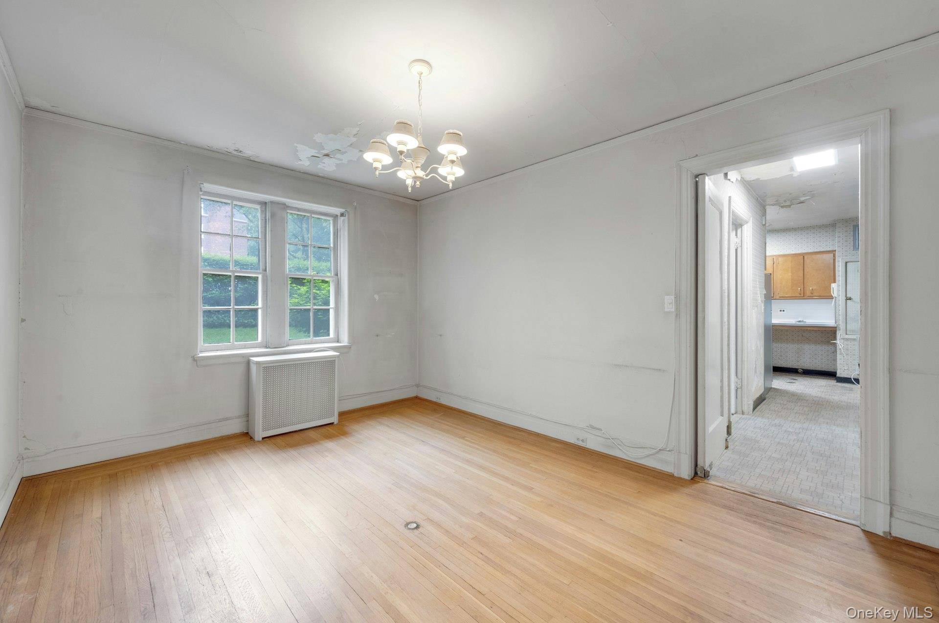 3 Alden Place, Unit 1A Bronxville, NY 10708 - Photo 9 of 29 an empty room with wooden floor chandelier and windows