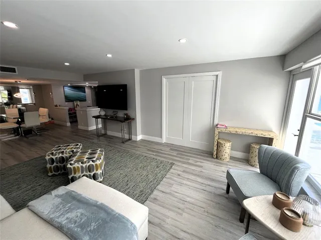 a living room with chairs furniture and a flat screen tv