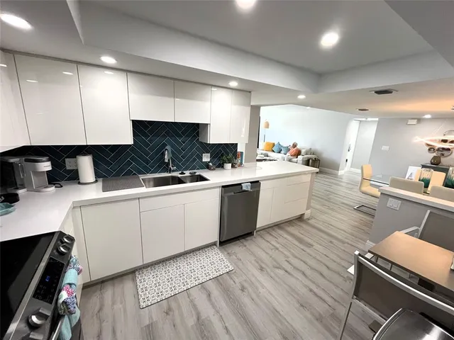 a view of a refrigerator in kitchen and dishwasher with wooden floor