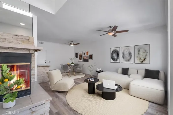 a living room with furniture a rug and a ceiling fan