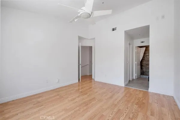 an empty room with closet and a ceiling fan