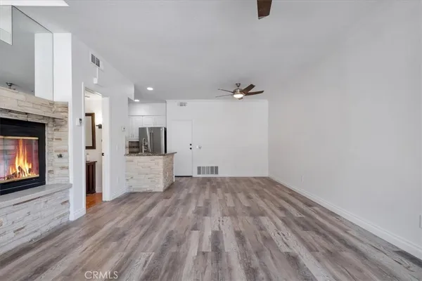 a view of empty room with wooden floor and fireplace