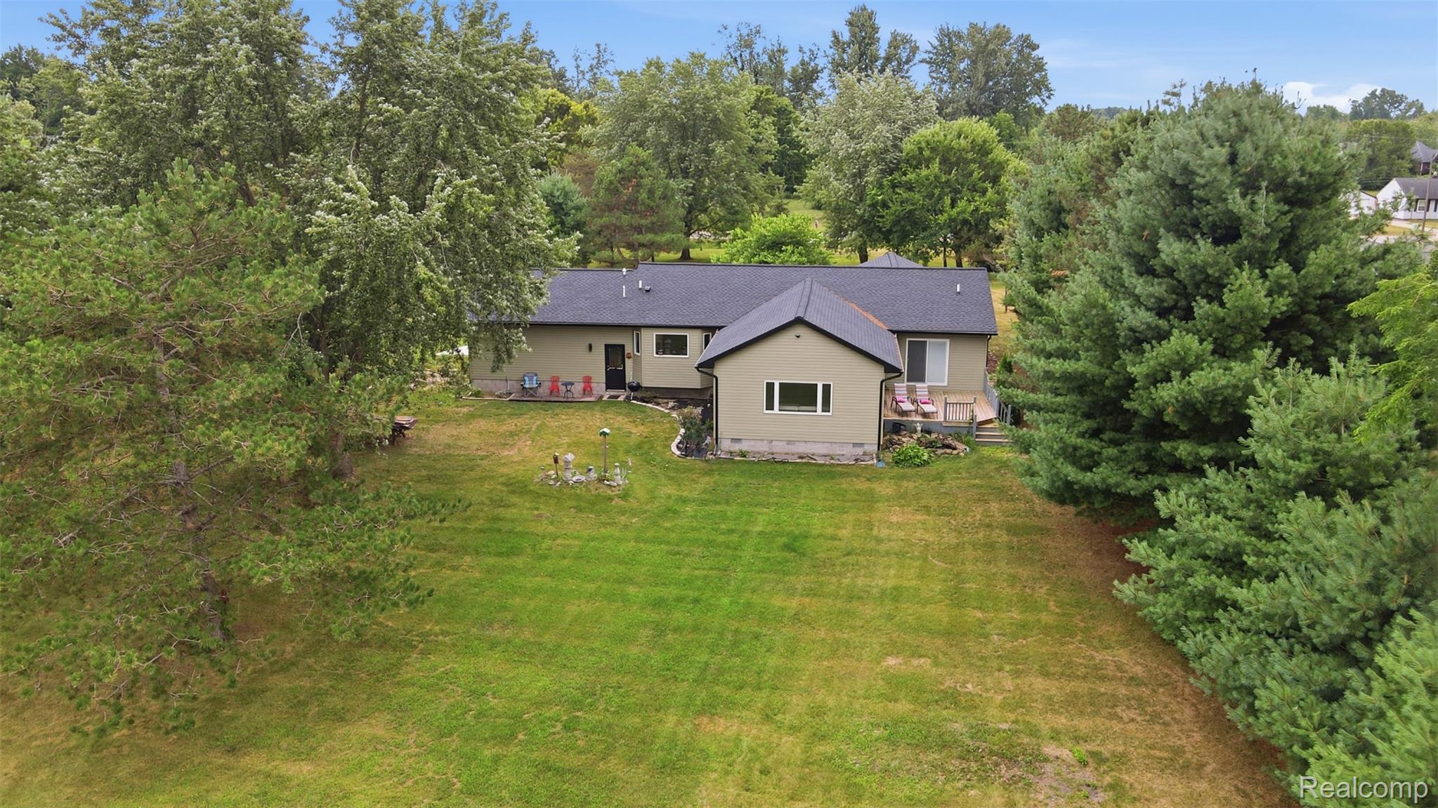 45738 Bemis Road Belleville, MI 48111 - Photo 52 of 52 Expansive green lawn surrounds a single-story residence with a dark shingle roof and light-colored siding