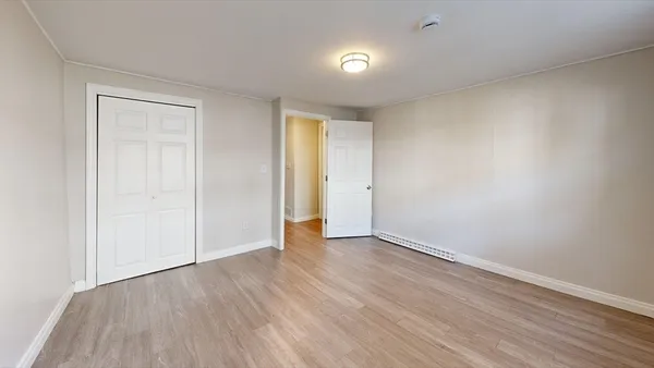 an empty room with wooden floor and closet