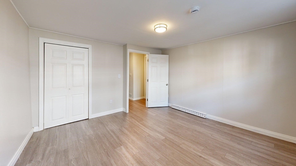 an empty room with wooden floor and closet