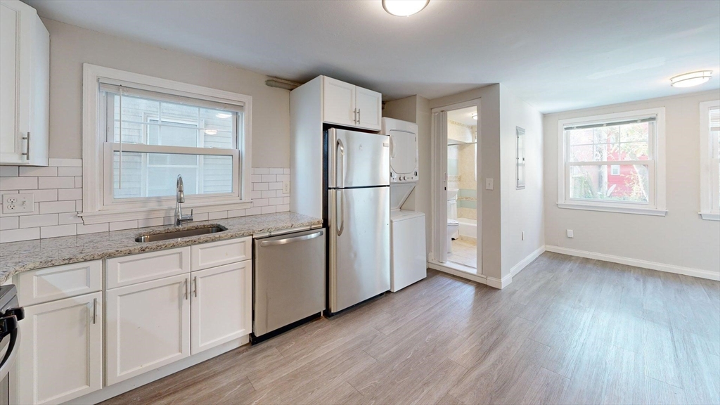 187 Maverick Street, Unit 3 Boston, MA 02128 - Photo 2 of 11 a kitchen with a refrigerator sink and a window