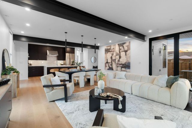 a living room with furniture a flat screen tv and a large window