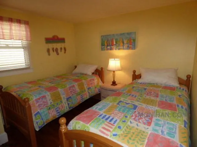 a bedroom with a bed and a lamp next to a window