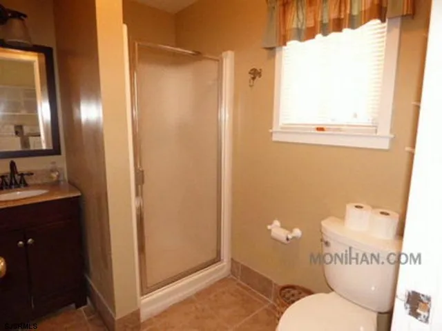 a bathroom with a sink mirror vanity and toilet