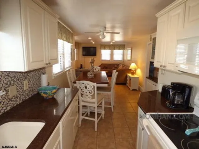 a kitchen with stainless steel appliances granite countertop a sink a stove counter space and living room