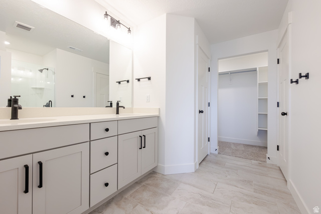 4812 Heartwood Road, Unit 424 Mapleton, UT 84664 - Photo 13 of 20 Full bathroom with double vanity, a shower stall, a walk in closet, and light marble finish floors