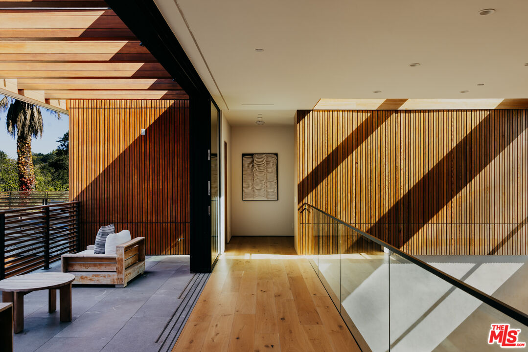 9705 Oak Pass Road Beverly Hills, CA 90210 - Photo 11 of 22 a balcony with wooden floor and furniture