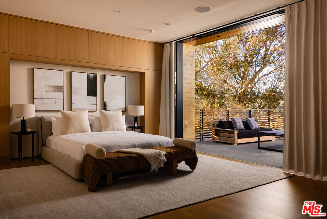 9705 Oak Pass Road Beverly Hills, CA 90210 - Photo 12 of 22 a bedroom with a bed couch and a large window with balcony view