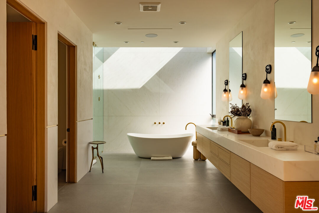 9705 Oak Pass Road Beverly Hills, CA 90210 - Photo 13 of 22 a bathroom with a double vanity sink mirror and bathtub