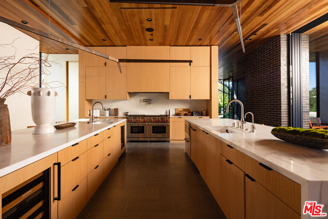 9705 Oak Pass Road Beverly Hills, CA 90210 - Photo 7 of 22 a large kitchen with stainless steel appliances sink a stove and cabinets