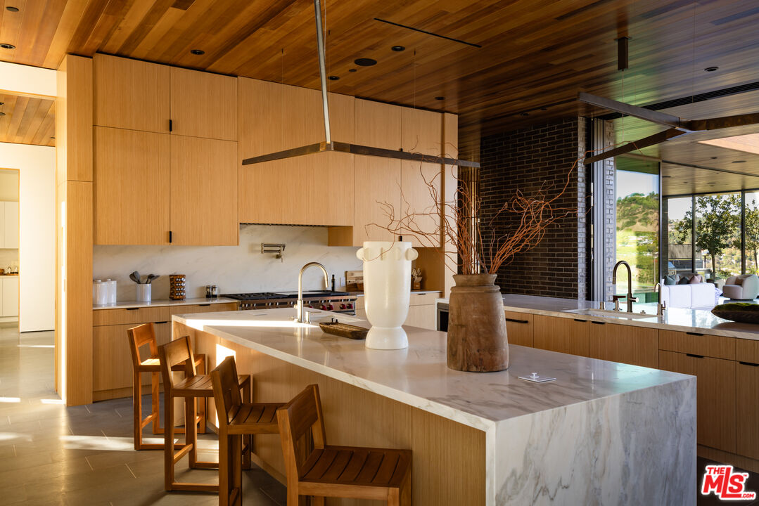 9705 Oak Pass Road Beverly Hills, CA 90210 - Photo 8 of 22 a kitchen with a stove a sink and a refrigerator