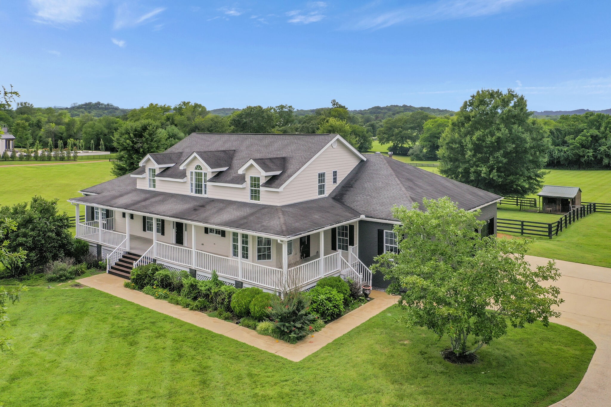 a aerial view of a house with a big yard and large trees