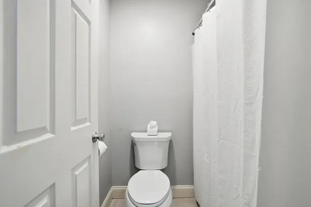 a white toilet sitting next to a white cabinet