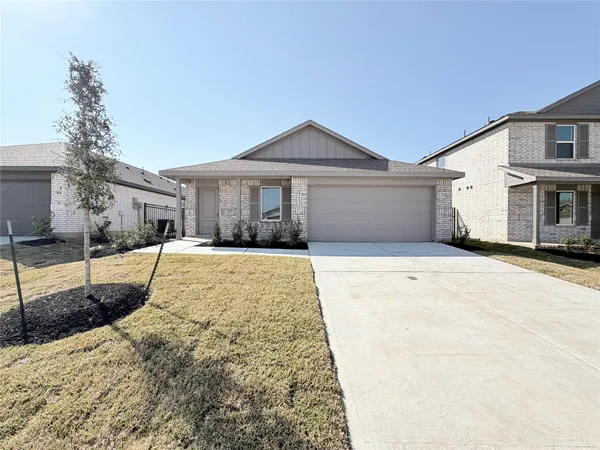 a front view of a house with a yard and potted plants