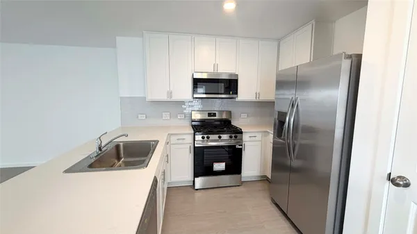 a kitchen with cabinets a refrigerator and a stove