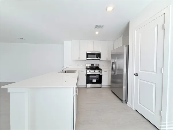 a kitchen with granite countertop white cabinets and white appliances