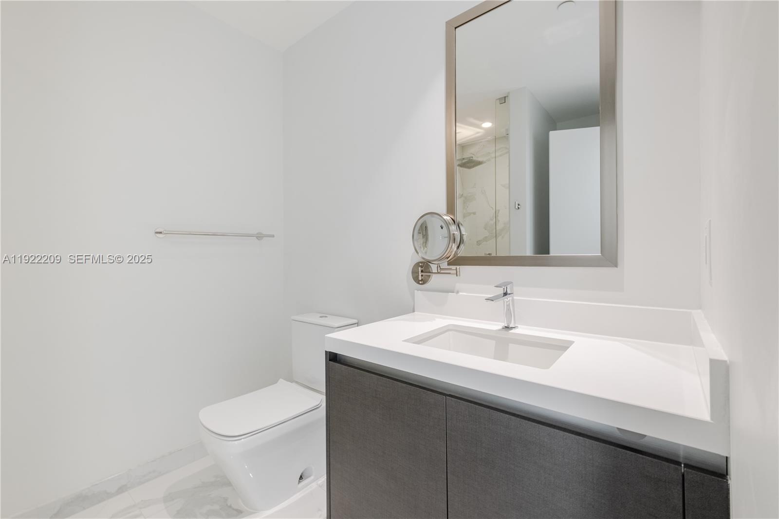 851 Northeast 1st Avenue, Unit 3911 Miami, FL 33132 - Photo 33 of 75 a bathroom with a sink a toilet and mirror