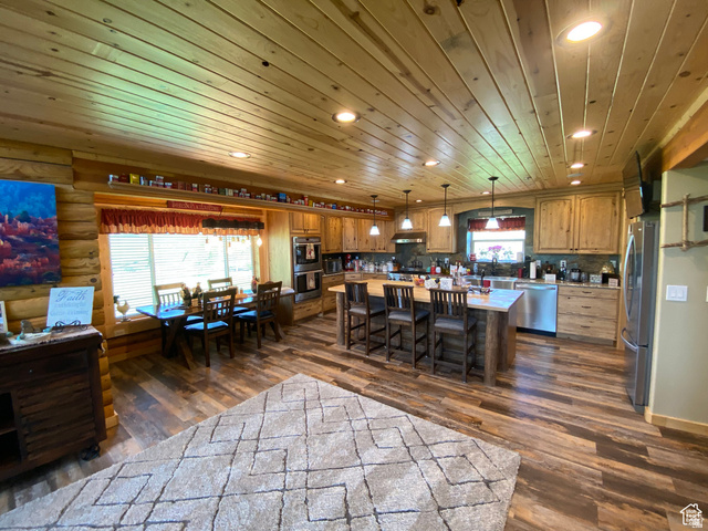 79 Auburn Forest Road Auburn, WY 83111 - Photo 20 of 76 Kitchen featuring a kitchen island, wood finish cabinets, stainless steel appliances, dark wood-style flooring, and wooden ceiling