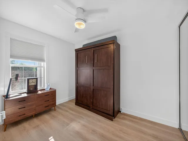 an empty room with mirror and a wooden floor