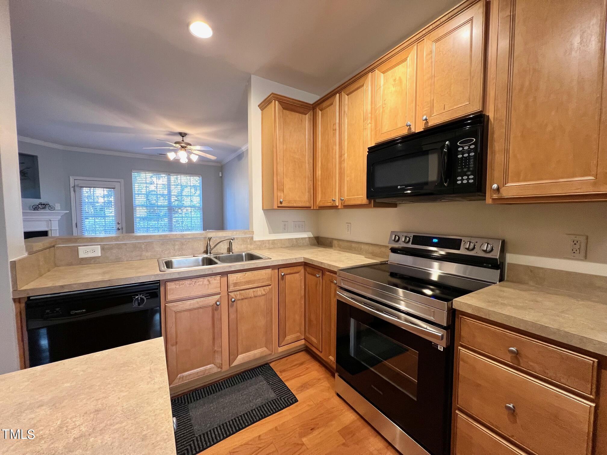 7652 Winners Edge Street Raleigh, NC 27617 - Photo 9 of 16 a kitchen with stainless steel appliances a stove sink microwave and cabinets