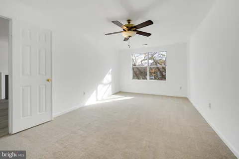 en empty room with windows and fan