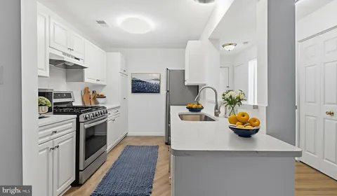a kitchen with a sink a stove and cabinets